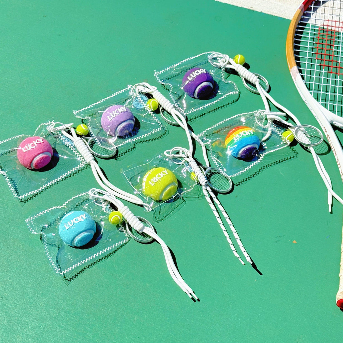 Tennis racket with colorful balls on a green court
